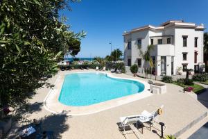 a swimming pool in front of a house at Villa Masetta - Luxury Suites in Mondello