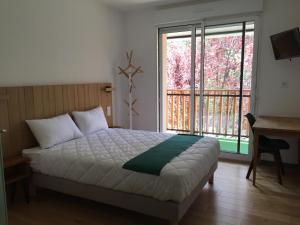 1 dormitorio con cama y ventana grande en Logis Hôtel Les TILLEULS en Bruère-Allichamps