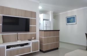 uma sala de estar com uma televisão de ecrã plano na parede em Excelente apto 3 quartos em Bombas, 100 metros do mar e 2 vagas de garagem em Bombinhas