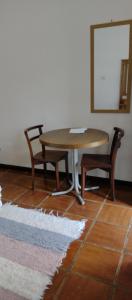einen Tisch, 2 Stühle, einen Tisch und einen Spiegel in der Unterkunft Recanto das Pedras in São Francisco Xavier