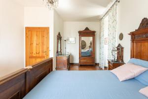 a bedroom with a blue bed and a wooden headboard at Podere con piscina sulle colline di Rimini in Rimini