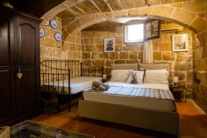 a bedroom with two beds in a stone wall at The Burrow Guest House in Tarxien