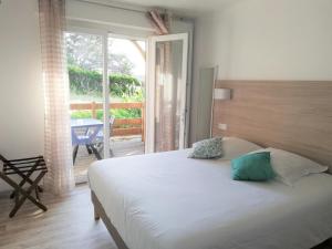 a bedroom with a large bed and a balcony at Hotel Atlantique in Mimizan-Plage