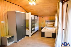 a bedroom with a bed in a room with wooden walls at Uzungöl Bungalow in Uzungol