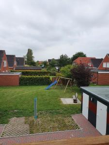 a yard with a playground with a swing at Apartmenthaus Robbe Luv in Neuharlingersiel