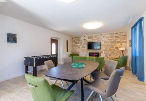 a dining room with a table and green chairs at Pepe&Lynn in Višnjan