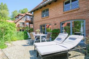 a patio with a table and chairs and a building at Dünenhof DÜNENHOF Whg. D-02 in Wustrow