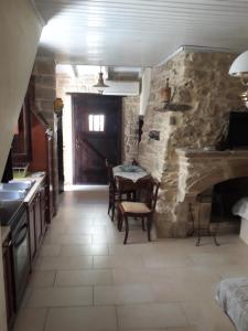uma cozinha com uma mesa e uma parede de pedra em Kritikies Elaia em Pitsidia