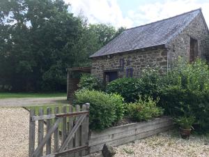 a stone house with a wooden fence in front of it at Chambre à la campagne in Québriac +12 photos
