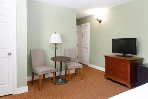 a room with two chairs and a table and a television at Admiral's Inn Resort in Ogunquit