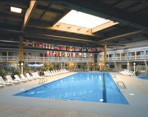 una gran piscina en un edificio con sillas en The Cove at Yarmouth en West Yarmouth