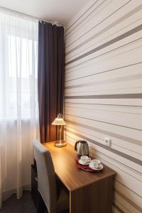 a room with a wooden table with a lamp on it at Arkada Hotel in Bučovice