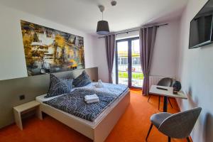 a bedroom with a bed and a chair and a window at Pension Berlin in Cheb