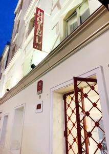 a white building with a sign above a door at Hotel Bellevue Montmartre in Paris