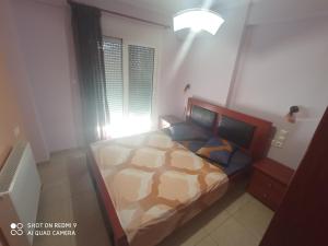 1 dormitorio con cama y ventana en Apostolia Lux Apartments, en Volos