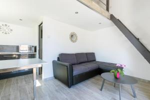 a living room with a couch and a table at Cosy Corner in Saint-Xandre +3 photos