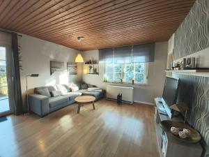 ein Wohnzimmer mit einem Sofa und einem Tisch in der Unterkunft Ferienhaus Drosselgasse 8 in Berumbur