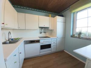 a kitchen with white cabinets and a sink at Ferienhaus Drosselgasse 8 in Berumbur