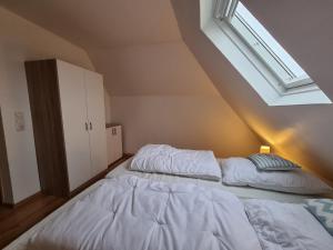 2 camas en una habitación con tragaluz en Ferienwohnung Schlickwanderer Klein, en Nessmersiel