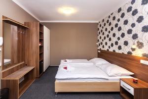 a bedroom with a bed with a wooden head board at Arkada Hotel in Bučovice