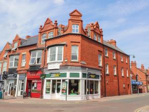 a large red brick building on a city street at Flat 2 in Prestatyn