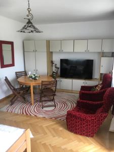 sala de estar con mesa, sillas y TV en Apartamenty, dom przy Parku w centrum Zamościa en Zamość