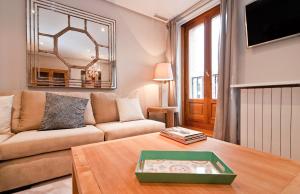 uma sala de estar com um sofá e uma mesa em Alcala I em Madrid