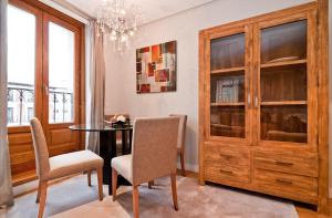 une salle à manger avec une table, des chaises et un lustre dans l'établissement Alcala I, à Madrid