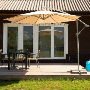 a patio with an umbrella and a table and chairs at Plateliai Samogitia Barn in Plateliai