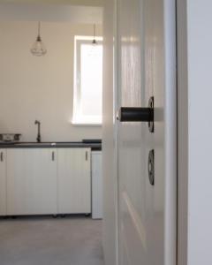 an open door in a kitchen with a window at Plateliai Samogitia Barn in Plateliai