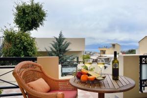 a table with glasses of wine and fruit on a balcony at SHINE VERANDA PRIVE APTS 7PERSONS in Plataniás