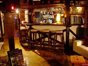 a bar with bar stools in a room at Pousada Arte Urquijo in Paraty
