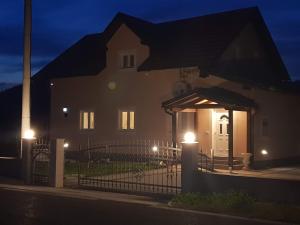 ein Haus mit einem Tor in der Nacht davor in der Unterkunft Villa Lady Di Plitvice in Vrhovine