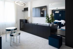 a living room with a black cabinet and two stools at Z Rooms Boutique in Zalaegerszeg