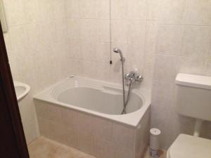 a bath tub in a bathroom with a toilet at De La Tour in Tirano