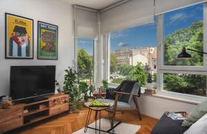 een woonkamer met een flatscreen-tv en een raam bij Place to be - Center apartment in Pula