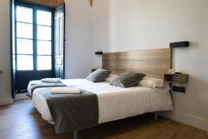 um quarto com 2 camas e uma cabeceira em madeira em Balhondo Open Village em Puebla de Alcocer