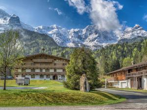 a large building with mountains in the background at Brandtnerhof Betriebe in Waidring