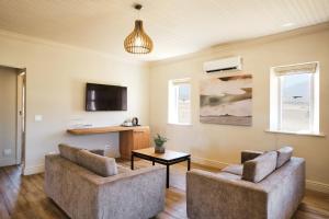ein Wohnzimmer mit 2 Stühlen und einem Tisch in der Unterkunft Rijk's Wine Estate & Hotel in Tulbagh