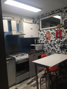 a kitchen with a stove and a table with chairs at Apartament Kopernika z antresolą in Toruń