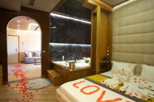 a bedroom with a bed and a bathroom with a sink at Vila One Beach Hotel in Durrës
