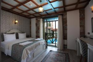 1 dormitorio con 1 cama y puerta corredera de cristal en Celsus Boutique Hotel en Selcuk