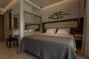 a bedroom with a large bed and a mirror at Lighthouse Apartments in Stoupa
