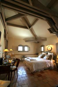 a bedroom with a large bed and a table at Hôtel Étoiles d'Orion in Marsolan