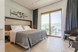 a hotel room with a bed and a balcony at Lighthouse Apartments in Stoupa