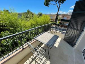 a patio with a table and a chair on a balcony at Villa Louise-Rose in Villeneuve-Loubet