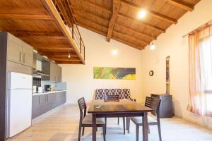 a kitchen and dining room with a table and chairs at Apartamentos El Capricho in Águeda del Caudillo