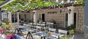 een patio met tafels, stoelen en planten bij Guest House Kolarin in Slano