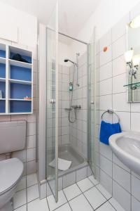 a bathroom with a shower and a toilet and a sink at Hotel Garni Benser Watt in Bensersiel