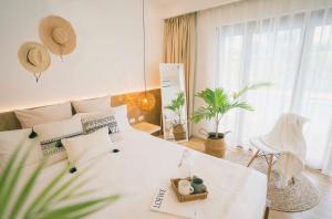 a white bedroom with a white bed and a plant at Ultra Mint Dive Resort in Panglao Island